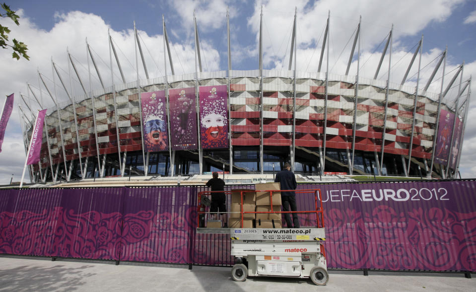 Workers decorate the fence surrounding Poland’s National Stadium in Warsaw, Poland, on Wednesday May 30, 2012. Poland is in full preparation mode as it counts down to the Euro 2012 football tournament that it is co-hosting with Ukraine starting on June 8. (AP Photo/Czarek Sokolowski)