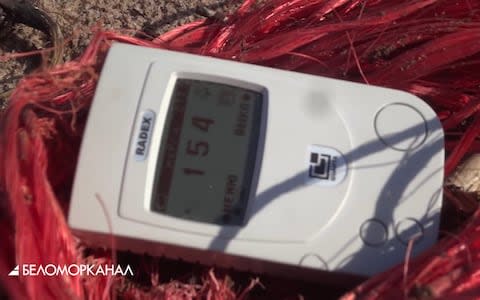 A dosemeter shows 154 microroentgens an hour near a red fishing line - Credit: YouTube