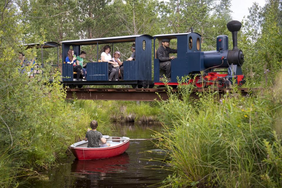 A miniature steam train runs across a bridge on Pavel Chilin's miniature personal narrow-gauge railway twisting through the grounds of his home in Ulyanovka village outside St. Petersburg, Russia Sunday, July 19, 2020. It took Chilin more than 10 years to build the 350-meter-long mini-railway complete with various branches, dead ends, circuit loops, and even three bridges.(AP Photo/Dmitri Lovetsky)