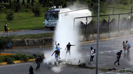 Riot security forces release jets of water from their water cannon on opposition supporters during clashes at a rally against Venezuelan President Nicolas Maduro's government in Caracas, Venezuela June 22, 2017. REUTERS/Carlos Garcia Rawlins