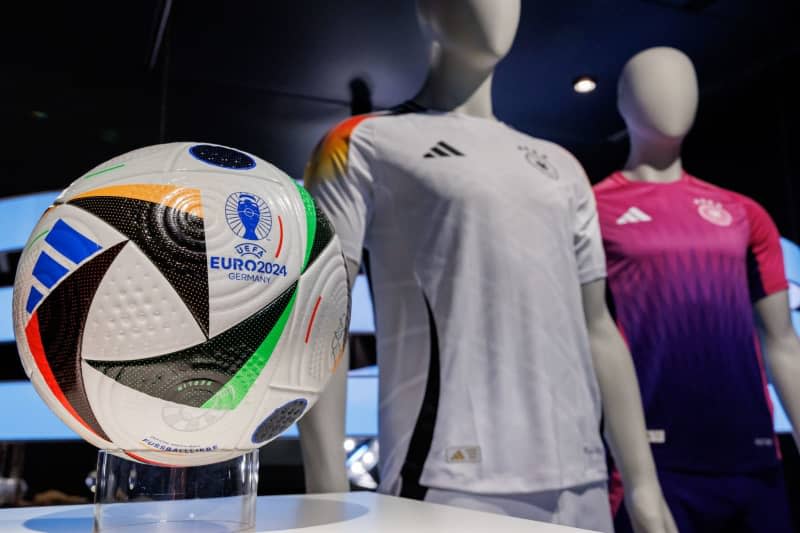 The official jerseys of the German national soccer team for the upcoming European Football Championship 2024 (UEFA EURO 2024) and the official match ball are on display at the headquarters of sporting goods manufacturer adidas AG. Daniel Karmann/dpa