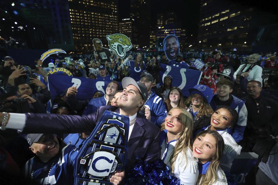 UCLA 's Laiatu Latu poses with fans after being chosen by the Indianapolis Colts with the 15th pick of the draft.