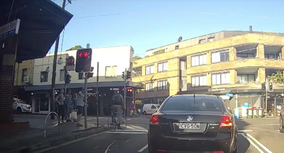 Following a verbal altercation, the cyclist then pedals off through a red light. Source: Facebook/ Voz Spoz