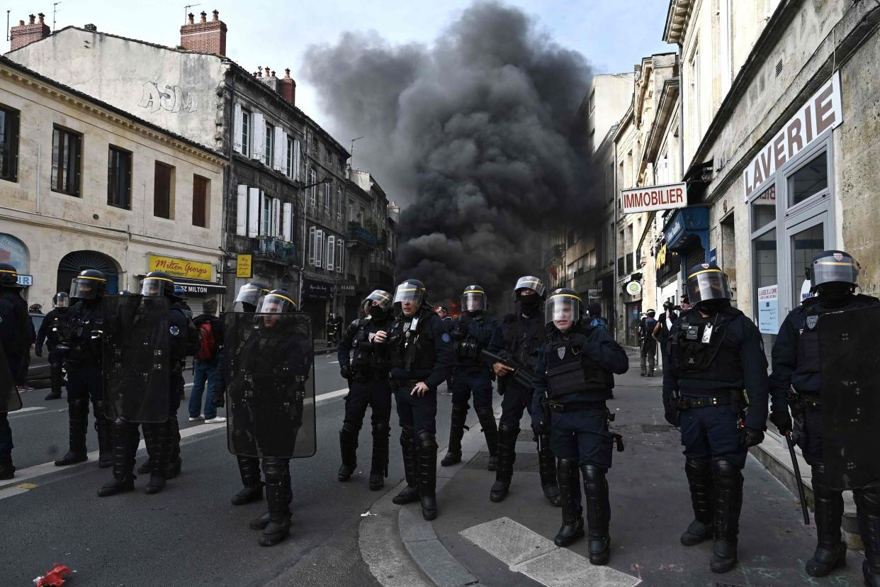 French Republican Security Corps officers hold a street as fire rages nearby (AFP/Getty)