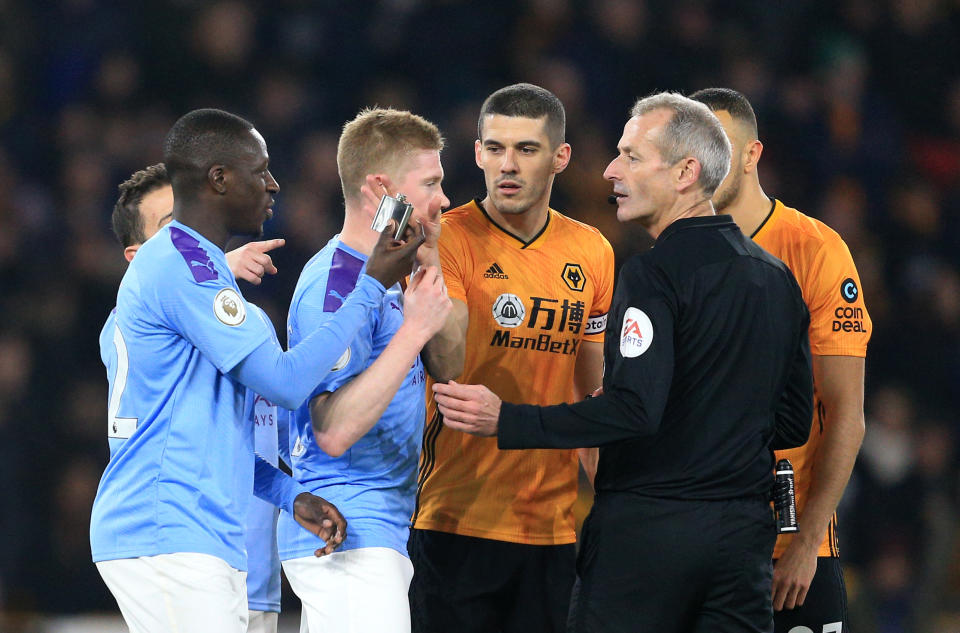 WOLVERHAMPTON, ENGLAND - DECEMBER 27: Benjamin Mendy of Manchester City hands an object thrown onto the pitch from the stands to Referee Martin Atkinson during the Premier League match between Wolverhampton Wanderers and Manchester City at Molineux on December 27, 2019 in Wolverhampton, United Kingdom. (Photo by Matt McNulty - Manchester City/Manchester City FC via Getty Images)