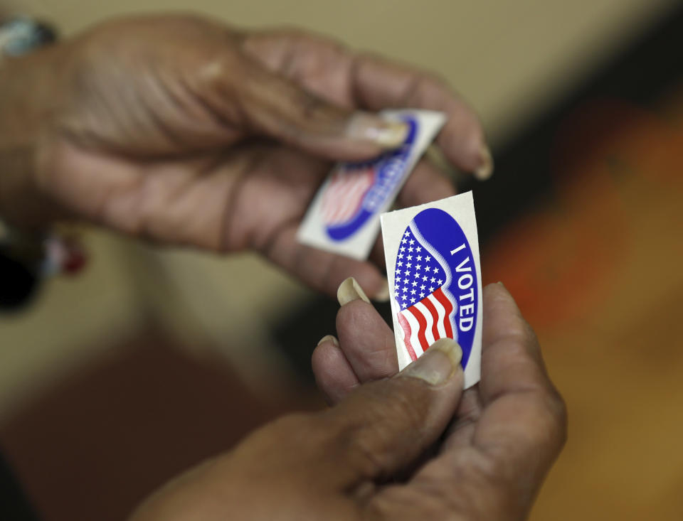 An election officer passes out "I Voted" stickers during the Super Tuesday primary at at Lincoln Terrace Elementary School. (Heather Rousseau/The Roanoke Times via AP)