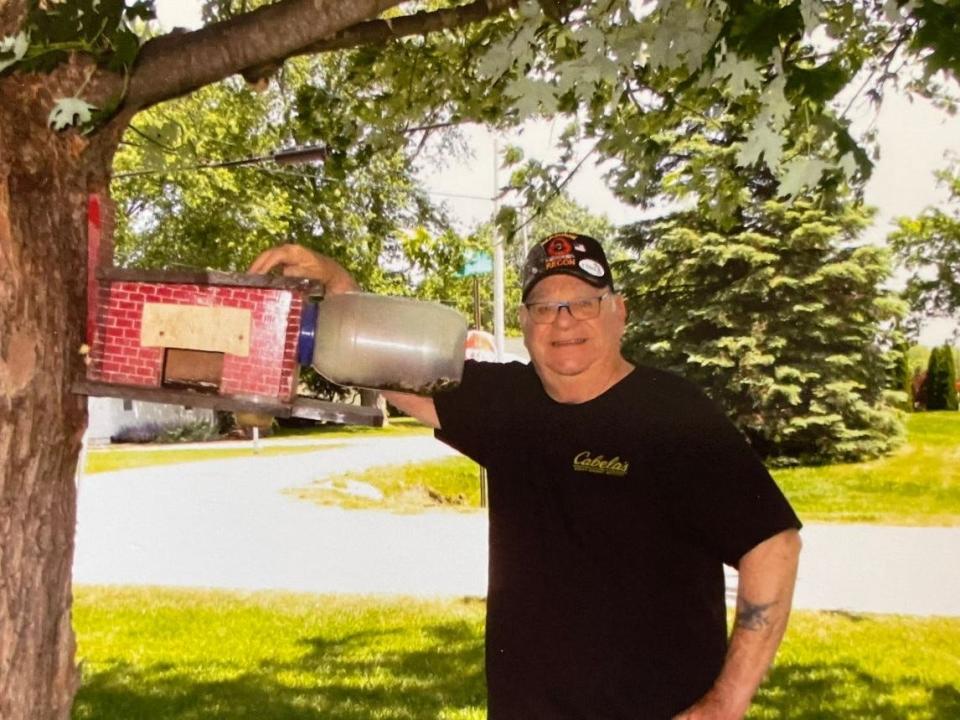Don Steinman Jr. is shown with one of the houses/feeders he builds for squirrels from wood and a plastic jug.