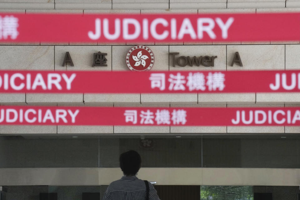 A man walks toward the main entrance to local court in Hong Kong Thursday, July 22, 2021. Hong Kong police charged two top editors and two editorial writers at Apple Daily with collusion weeks after the city's largest pro-democracy newspaper was forced to cease publication and its assets were frozen. All four were charged with conspiring to "collude with a foreign country or with external elements to endanger national security" under the city's year-old national security law and appeared in court Thursday. (AP Photo/Vincent Yu)