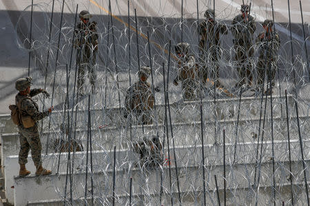 FILE PHOTO: U.S. Marines help to build a concertina wire barricade at the U.S. Mexico border in preparation for the arrival of a caravan of migrants at the San Ysidro border crossing in San Diego, California, U.S., November 13, 2018. REUTERS/Mike Blake/File Photo