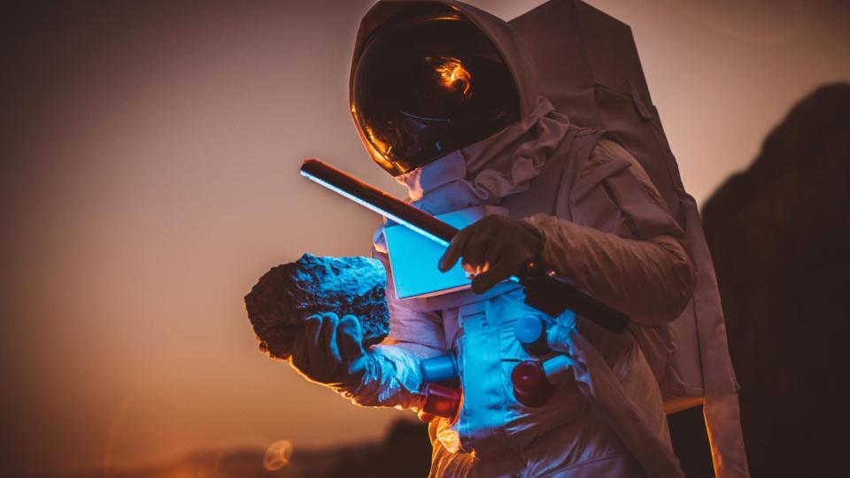 Recreación de un astronauta con una roca en la mano.