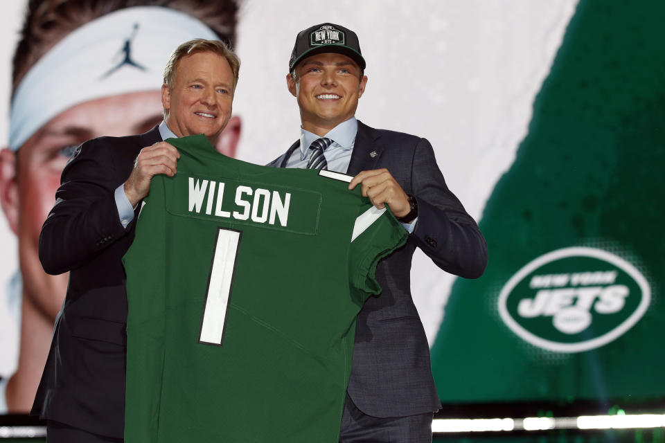 FILE - BYU quarterback Zach Wilson holds a New York Jets jersey with NFL commissioner Roger Goodell after being selected second overall by the team in the first round of the NFL football draft, Thursday, April 29, 2021, in Cleveland. Teams are using premium draft picks on quarterbacks at an increasingly high rate. Still, the league-wide hit rate remains largely a tossup. (AP Photo/Jeff Haynes, File)