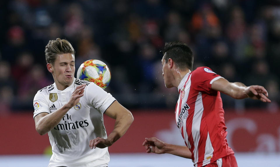 Real Madrid's Marcos Llorente, left, duels for the ball with Girona's Bernardo Espinosa during a Spanish Copa del Rey soccer match between Girona and Real Madrid at the Montilivi stadium in Girona, Spain, Thursday, Jan. 31, 2019. (AP Photo/Manu Fernandez)