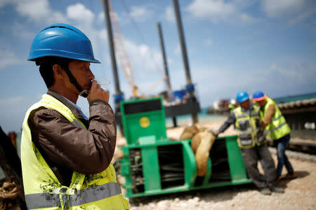 FILE PHOTO: Chinese construction workers work during a media tour of the construction of a new port in the southern city of Ashdod, Israel April 12, 2016. REUTERS/Amir Cohen/File Photo