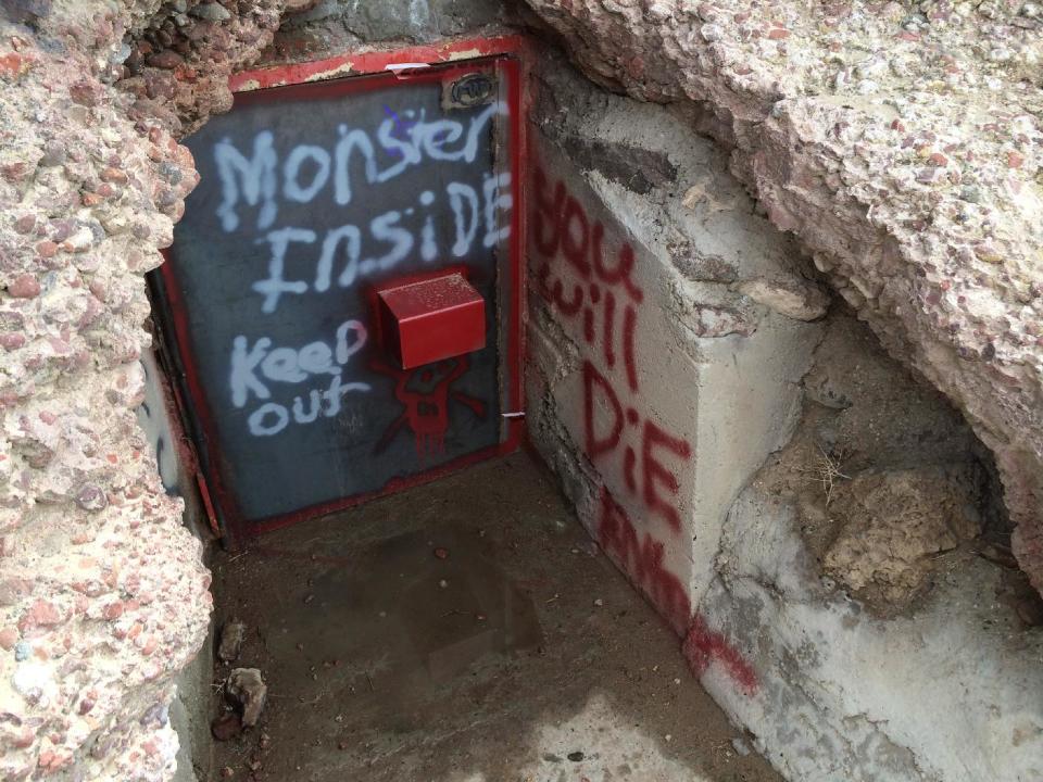 This undated image provided by the Bureau of Land Management shows the vandalized entrance to Hidden Cave near Fallon, Nev. Federal officials are offering a $1,000 reward after someone spray-painted phrases at the archaeological site. Public tours to Hidden Cave are temporarily suspended while law enforcement investigates. (AP Photo/Bureau of Land Management)