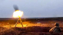 In this photo taken from video provided by the Russian Defense Ministry Press Service on Tuesday, Jan. 25, 2022, A Russian fires a mortar as he attends a military exercising at a training ground in Russia. (Russian Defense Ministry Press Service via AP)