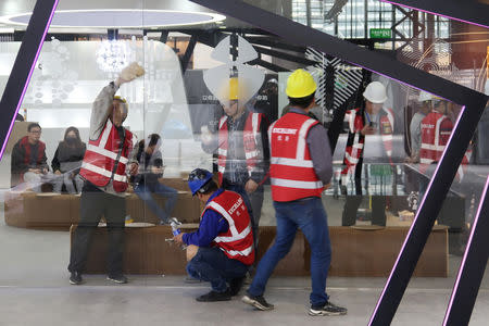 Workers set up the display stand for Chinese EV startup Singulato Motors in preparation for the upcoming auto show in Shanghai, China April 14, 2019. Picture taken April 14, 2019. REUTERS/Norihiko Shirouzu