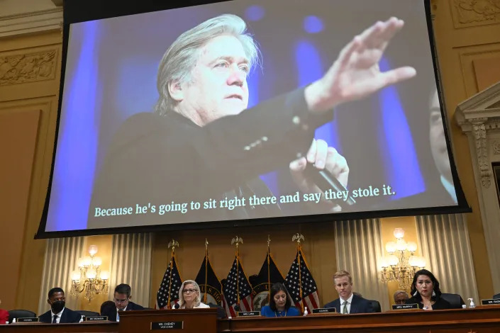 A video of Steve Bannon is displayed on a screen above the House Select Committee.