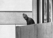 FILE - A member of the Arab Commando group which seized members of the Israeli Olympic Team at their quarters at the Olympic Village appearing with a hood over his face stands on the balcony of the building where the commandos held members of the Israeli team hostage in Munich, Sept. 5, 1972. The families of 11 Israeli athletes killed by Palestinian attackers at the 1972 Summer Olympics in Munich and the German government are close to reaching a deal over the long-disputed amount of the compensation. (AP Photo/Kurt Strumpf, File)