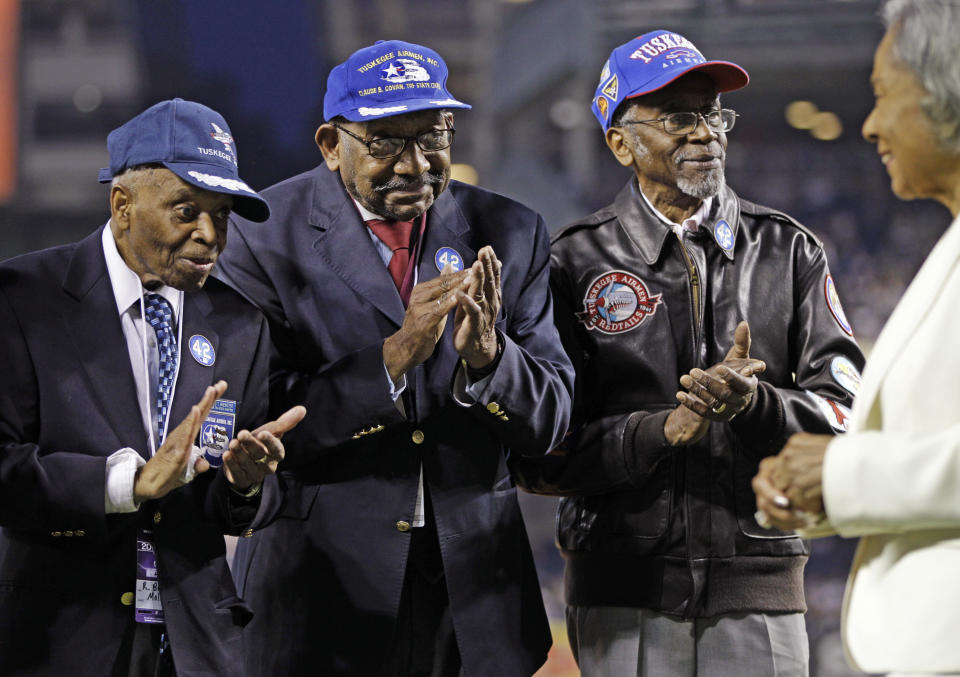 FILE - In this April 15, 2012 file photo, from left, Tuskeegee Airmen Reginald Brewster, Dabney Montgomery and Wilfred DeFour applaud as Jackie Robinson's widow Rachel Robinson, far right, is introduced on Jackie Robinson Day before the New York Yankees' baseball game against the Los Angeles Angels at Yankee Stadium in New York. DeFour has died at 100 years of age. Police say a health aide found him unconscious and unresponsive inside his Harlem apartment Saturday, Dec. 8, 2018. Police say he appears to have died from natural causes. (AP Photo/Kathy Willens, File)