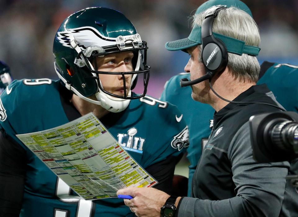 FILE - In this Feb. 4, 2018, file photo, Philadelphia Eagles head coach Doug Pederson, right, talks to Nick Foles during the first half of the NFL Super Bowl 52 football game against the New England Patriots, in Minneapolis. Facing the mighty New England Patriots on the NFL's biggest stage, Philadelphia Eagles coach Doug Pederson's decision to try a trick play _ the "Philly Special" _ on a fourth down late in the first half of Super Bowl 52 will be remembered as one of the gutsiest calls in sports history. That signature moment between Foles and Pederson standing on the sideline discussing the play was turned into a bronze statue that sits outside the team's stadium as a reminder of the greatest play in franchise history. (AP Photo/Matt York, File)