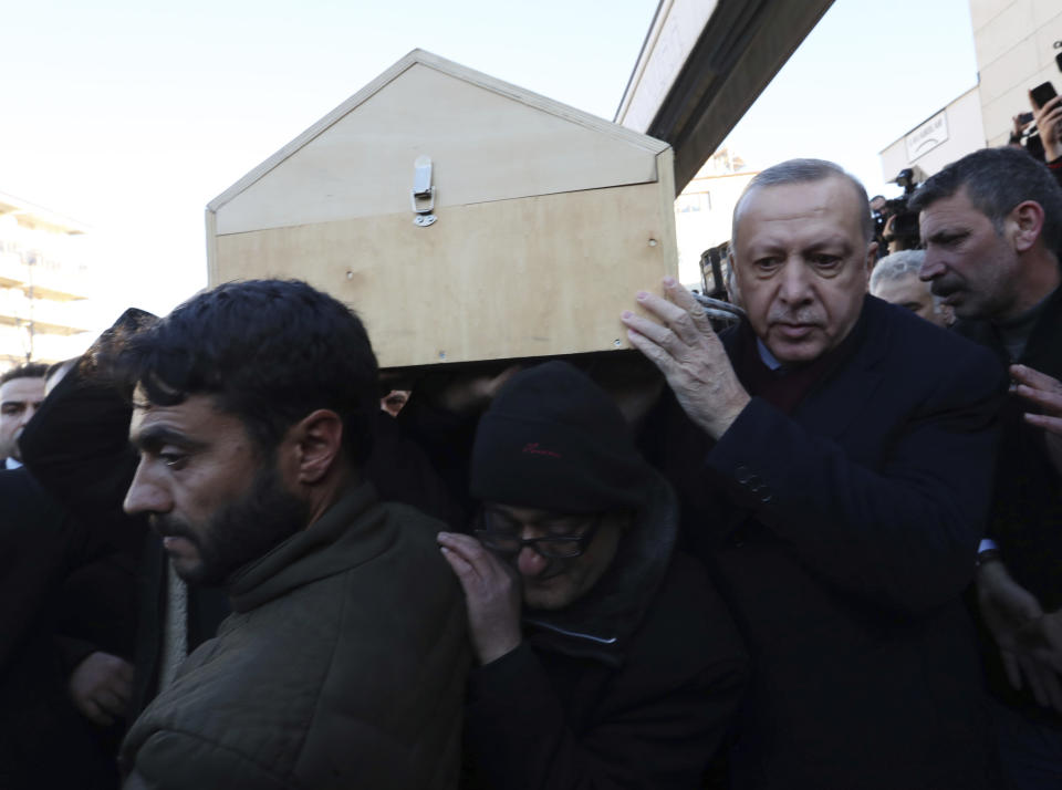 Turkey's President Recep Tayyip Erdogan carries the coffin of a victim after an earthquake hit Elazig, eastern Turkey, Friday, during the funeral procession for Salih Civelek and Aysegul Civelek, Saturday, Jan. 25, 2020. Rescuers continued searching for people buried under the rubble of collapsed buildings while emergency workers and security forces distributed tents, beds and blankets in the affected areas. Mosques, schools, sports halls and student dormitories were opened for hundreds who left their homes after the quake. (Presidential Press Service via AP, Pool)