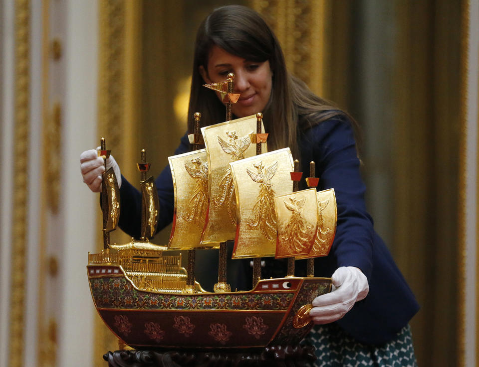 <p>Hannah Belcher, Ausstellungskoordinatorin des Royal Collection Trust, inspiziert das „Vessel of Friendship“. Das Model des „Schatzschiffes”, das im 15. Jahrhundert unter dem Kommando des chinesischen Admirals Zheng He stand und 2015 vom chinesischen Präsidenten Xi Jinping übergeben wurde, ist ein Symbol der Freundschaft – Montag, 3. April 2017, Buckingham Palace, London. (Frank Augstein/AP) </p>