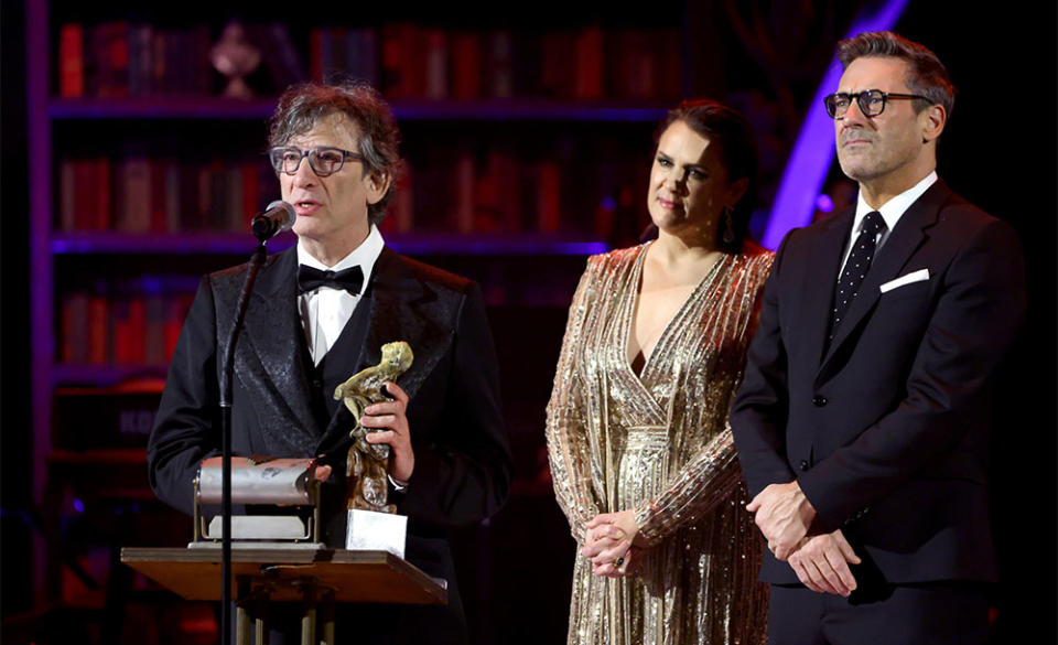 Honoree Neil Gaiman accepts the Visionary Award from Founder and CEO of The Art of Elysium Jennifer Howell and Jon Hamm onstage during The Art of Elysium's 25th Anniversary HEAVEN Gala at The Wiltern on January 06, 2024 in Los Angeles, California.