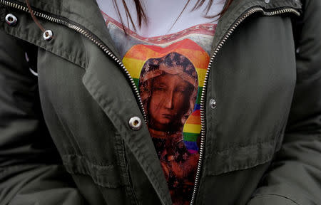 A woman wears a shirt displaying the "Black Madonna of Czestochowa" with a rainbow-coloured halo, at a protest in support of Elzbieta Podlesna, the author of an image depicting the Virgin Mary with the halo, reminiscent of the LGBT flag, who was detained for offending religious beliefs, in Warsaw, Poland May 7, 2019. REUTERS/Kacper Pempel