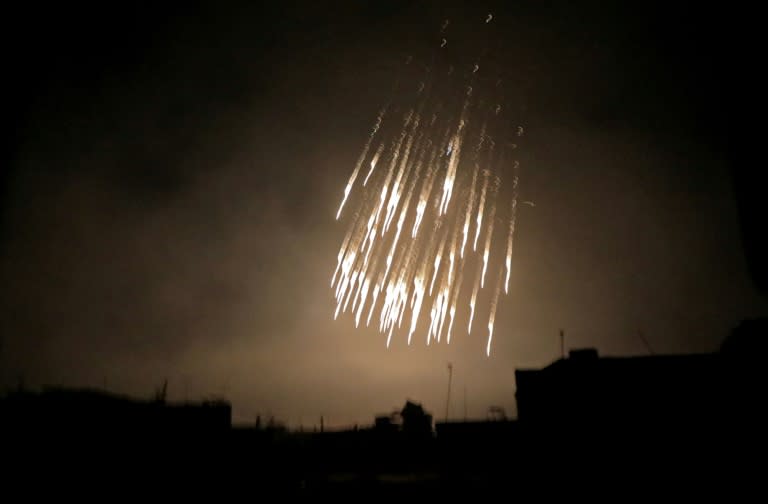 White streams apparently trailing incendiary munitions rain down on the largest Eastern Ghouta town of Douma before dawn on March 23, 2018