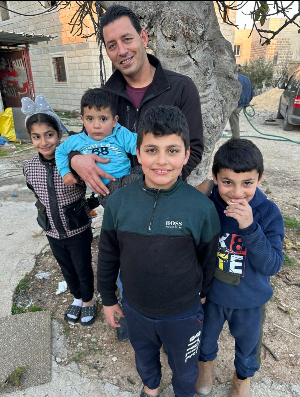Omar Zawharah, the West Bank high school teacher who showed Mark Patinkin around the West Bank for a day, holding his nephew and with his daughter and two sons.