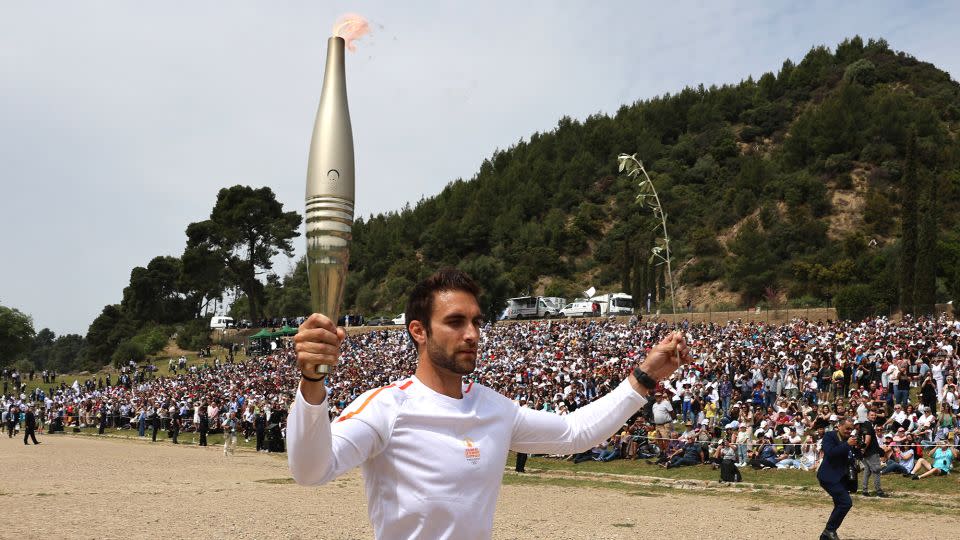 Ntouskos carrying the touch during the start of the relay. Over 600 torchbearers will take part in a 5,000km journey across Greece over the next 11 days before the flame is handed over to France. - Louisa Gouliamaki/Reuters
