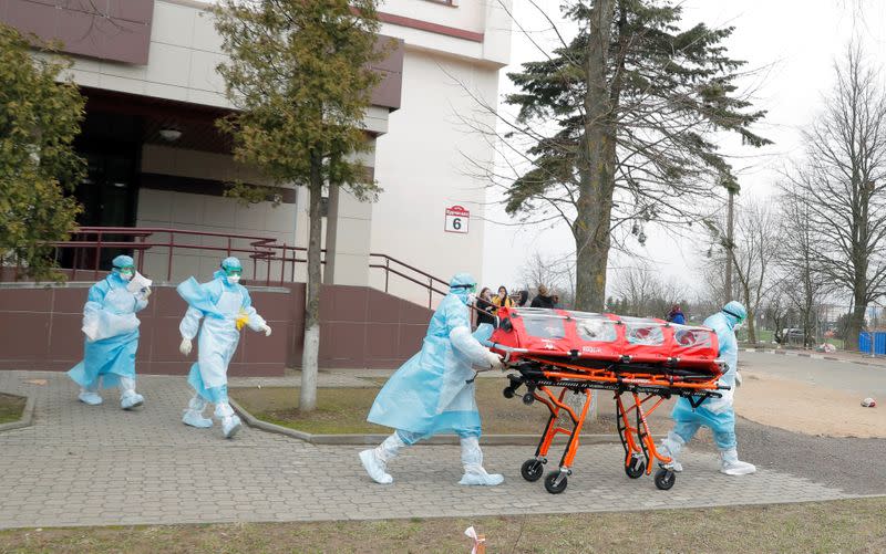 Medical employees wearing protective suits carry capsule with a woman as a measure to fight against the coronavirus contagion (COVID-19)