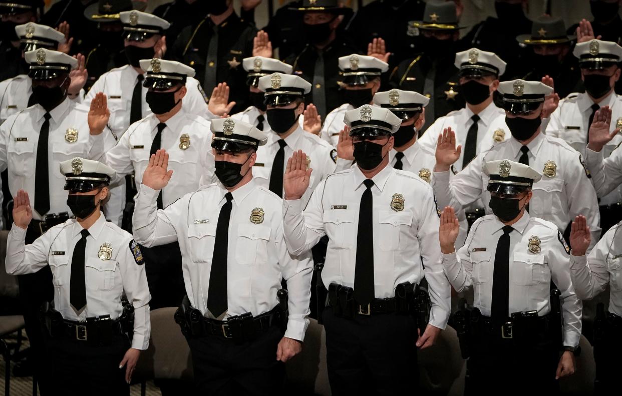 Recruits take the oath of office during the Columbus Division of Police graduation ceremony for its 136th recruit class at the Columbus Police Academy on Jan. 14, 2022. Amy DeLong, executive director of the Columbus Civil Service Commission, has recommended that the city stop the filling of nonpolitical "classified" city jobs including police officers using competitive test scores.