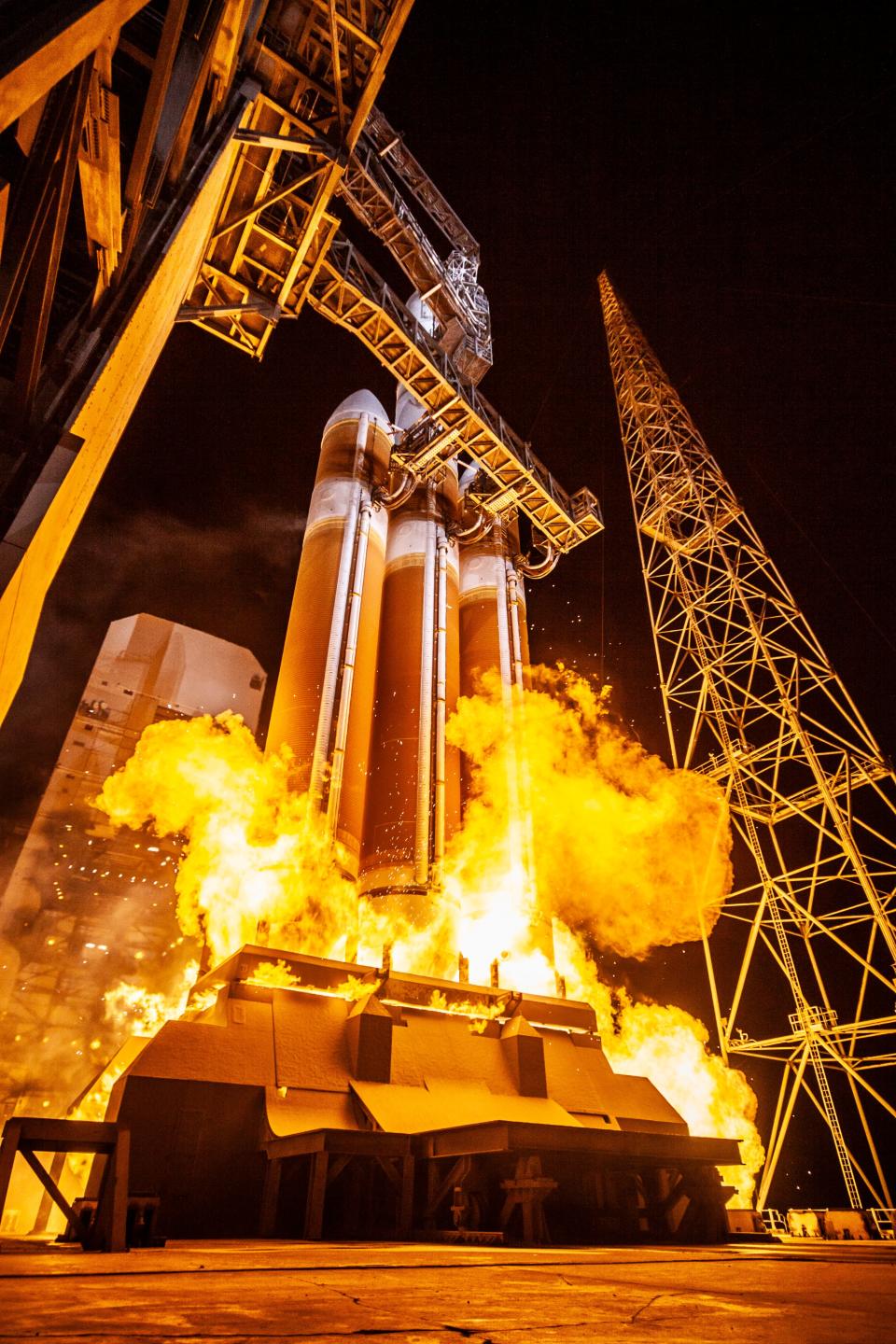 a plume of fire bursts from a rocket as it lifts off