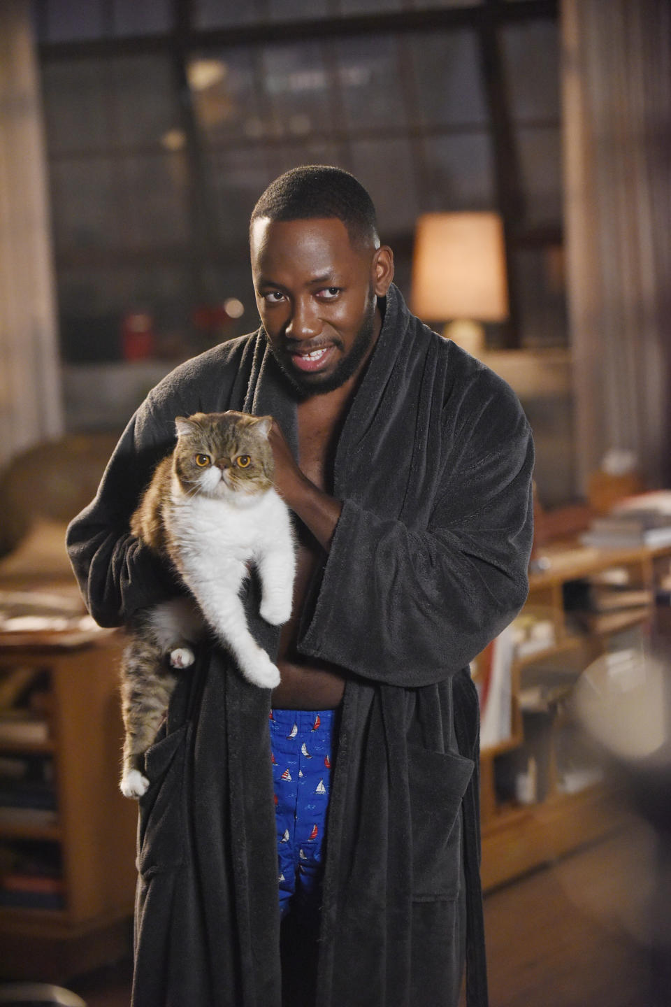 his character in a robe holding his cat