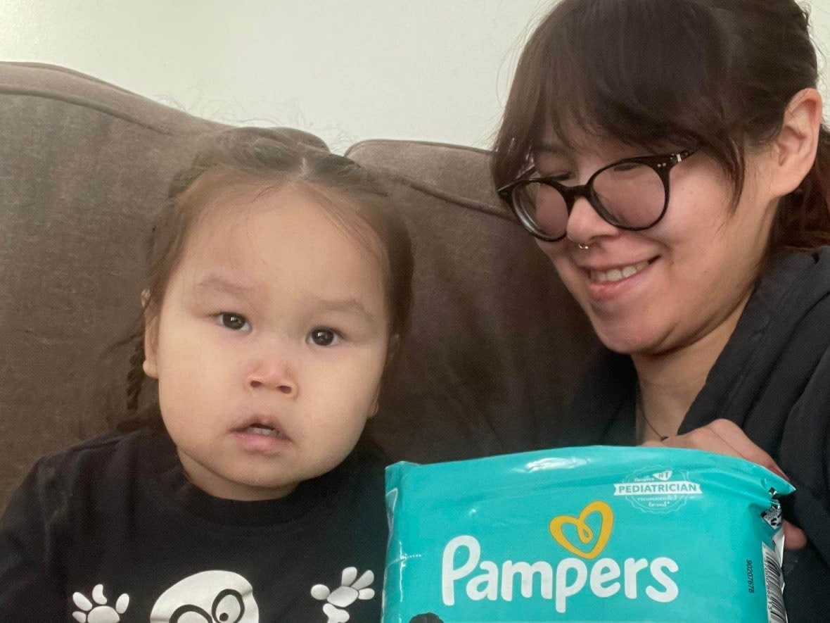 Kourtney Leanne Wolkie and her son Connor of Paulatuk, N.W.T., take a picture with some donated infant supplies. (Submitted by Kourtney Leanne Wolkie - image credit)