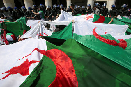 FILE PHOTO: Police members stand guard as students carry national flags during an anti-government protest in Algiers, Algeria May 14, 2019. REUTERS/Ramzi Boudina/File Photo