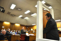 Investigating officer Captain Mike van Aardt, right, is asked by state prosecutor, Gerrie Nel, center, to demonstrate the opening and closing of the toilet door through which Reeva Steenkamp was shot and killed at the murder trial of paralympian Oscar Pistorius in court in Pretoria, South Africa, Monday, April 14, 2014. Pistorius is charged with the murder of Steenkamp, on Valentines Day in 2013. (AP Photo/Antoine de Ras, Pool)