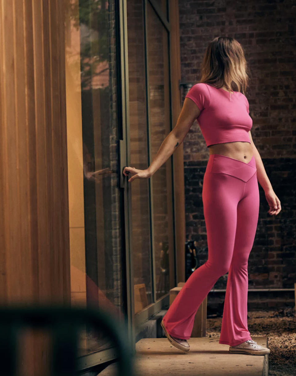 Model in the pink leggings stepping onto patio