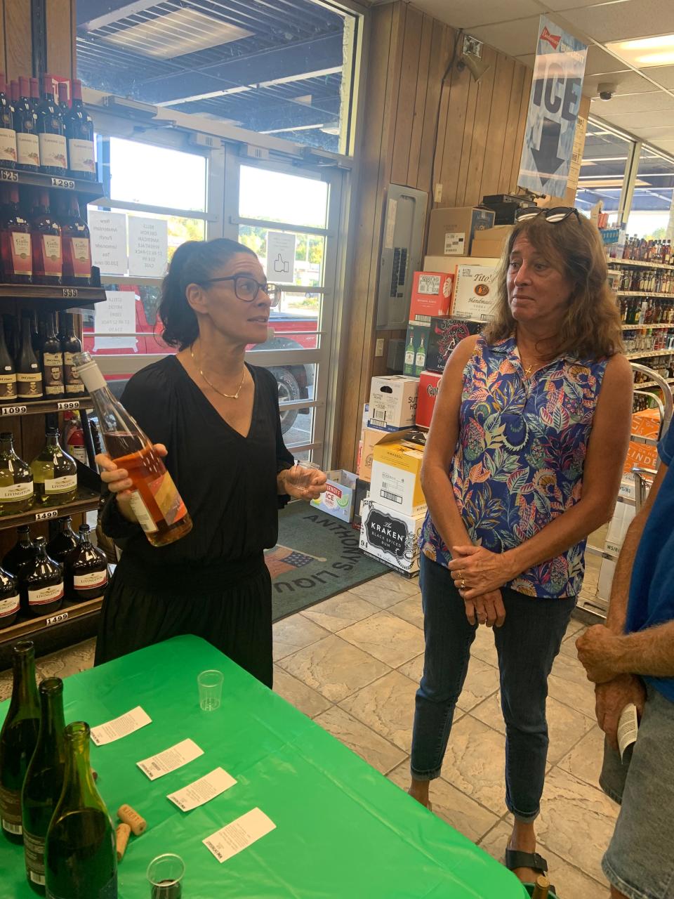 Kali Kopley, left, displays a bottle of her Lumen wine brand to Kathy Perry during a tasting event at Anthony's Liquor Mart in Gardner on Thursday.