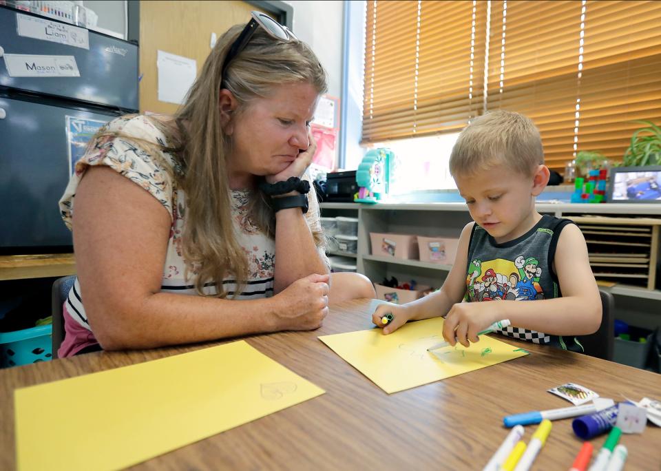 William Olsen makes a card for behavior specialist Nancy Hidde on her last day at the Bridges Child Enrichment Center in Appleton.