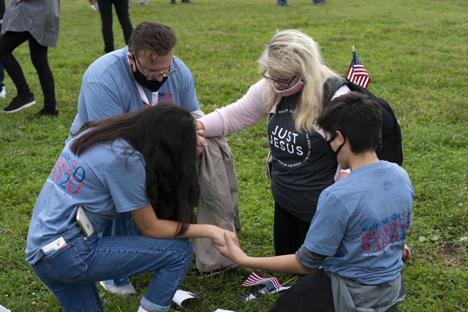 Followers of Franklin Graham stop to pray as they march from the Lincoln Memorial to Capitol Hill, during the Prayer March at the National Mall, in Washington, Saturday, Sept. 26, 2020. (AP Photo/Jose Luis Magana)