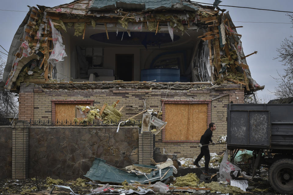 A local resident works to clean the debris from damaged house after Russian shelling in Kramatorsk, Ukraine, Thursday, Nov. 10, 2022. (AP Photo/Andriy Andriyenko)