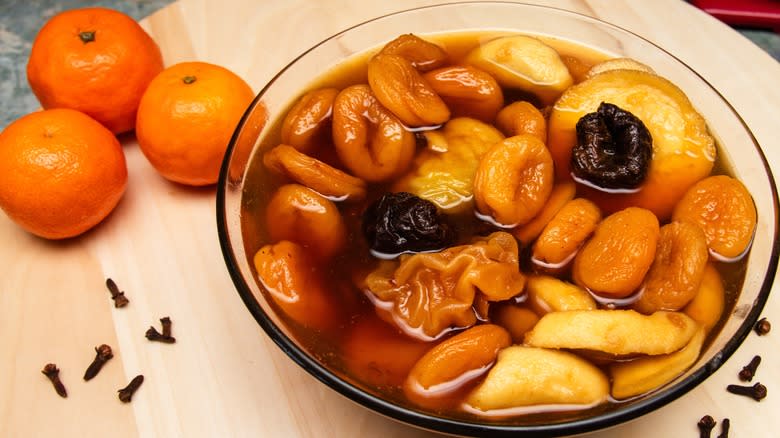 Dried fruits soaking in liquid next to clementines 