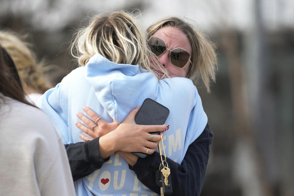 Students hug on the Michigan State University campus in East Lansing, Mich., Tuesday, Feb. 14, 2023. A gunman killed several people and wounded others at Michigan State University. Police said early Tuesday that the shooter eventually killed himself. (AP Photo/Paul Sancya)