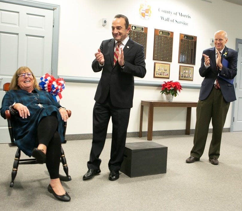 Morris County Commissioner Kathryn DeFillippo is presented with a rocking chair, the traditional gift for a retiring commissioner, at the commissioner's meeting on Dec. 7 in Morristown. The Roxbury resident chose not to run for a fourth term this year. With her are current Commissioner Director Tayfun Selen, center, and John Krickus, who has been chosen to lead the board in 2023.