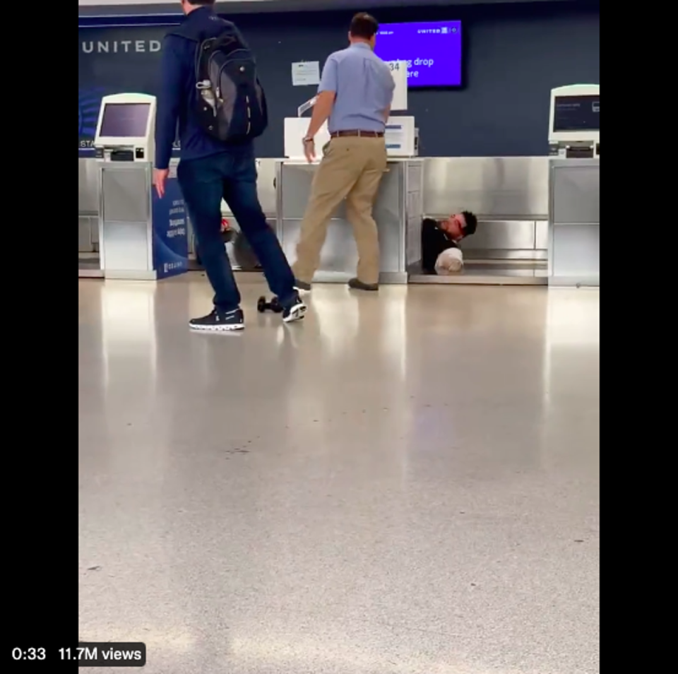 A United Airlines worker and a passenger got into a fist fight at Newark International Airport, leading to the employee getting knocked over the check-in desk and onto the conveyor belt. (Twitter/screengrab)