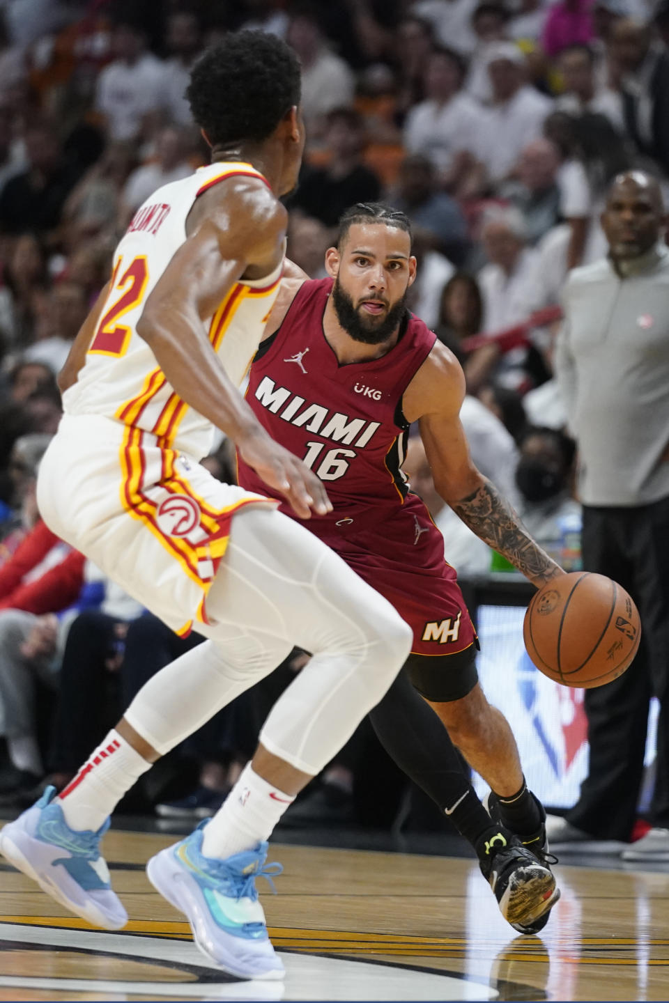 Miami Heat forward Caleb Martin (16) drives to the basket against Atlanta Hawks forward De'Andre Hunter (12) during the first half of Game 5 of an NBA basketball first-round playoff series, Tuesday, April 26, 2022, in Miami. (AP Photo/Wilfredo Lee)