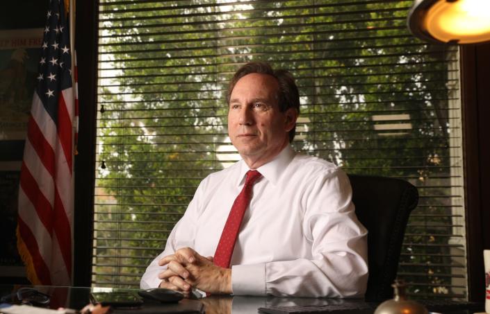 A person sits at a desk in front of a window.