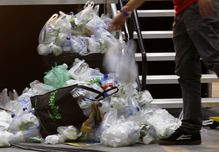 A man tosses a plastic bag over a pile of trash after an event in Singapore, April 28, 2018. Picture taken April 28, 2018. REUTERS/Feline Lim